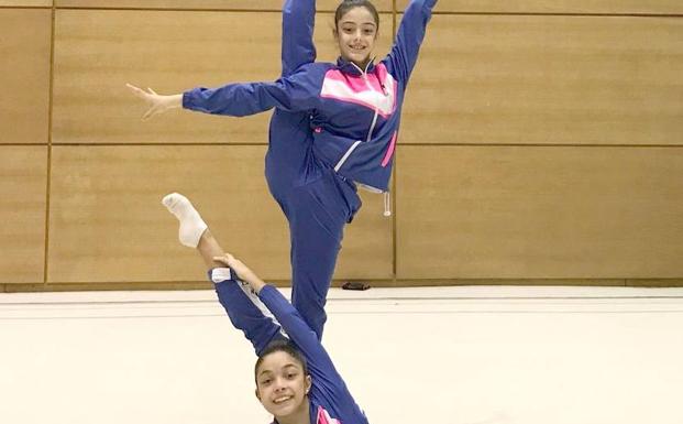 Las dos gimnastas en una foto con su club.