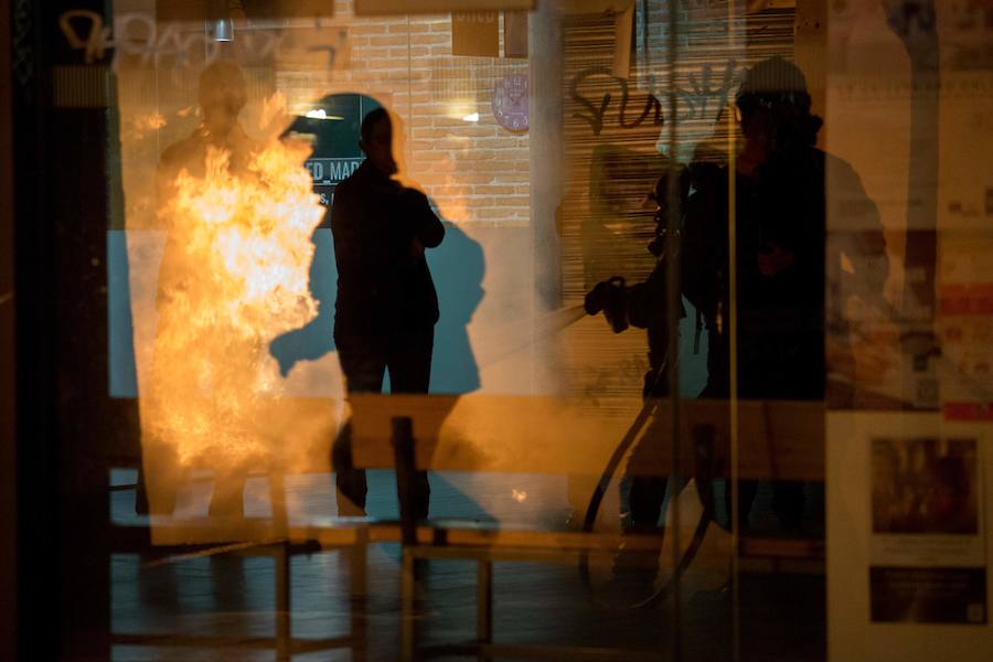 Un grupo de más de medio centenar de personas han quemado contenedores y causado desperfectos en el mobiliario urbano en el madrileño barrio de Lavapiés tras la muerte este jueves de un mantero de 35 años y origen subsahariano a causa de una parada cardiorrespiratoria.