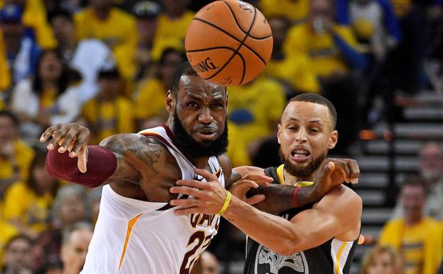 James (i) y Curry pugnan por el balón. 