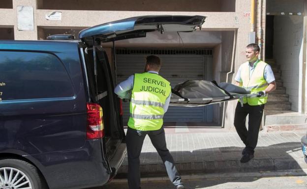 El servicio judicial retira el cadáver de la mujer asesinada en Badalona.