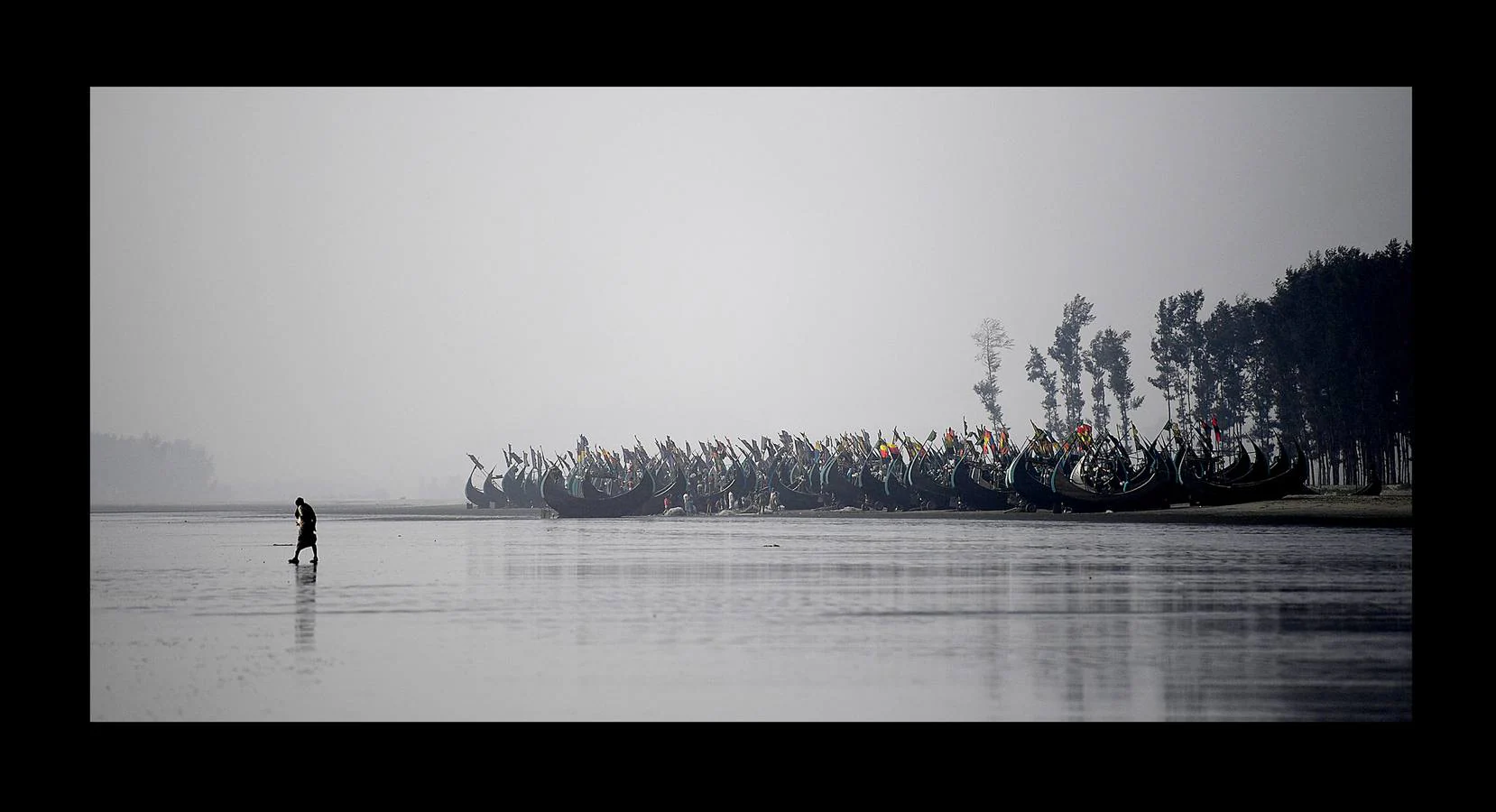 Una parte de los refugiados Rohingya que huyeron de Myanmar han encontrado trabajo en las pesquerías de la vecina Bangladesh. El campamento de refugiados de Shamlapur, cercano a una colonia de pescadores, es el hogar de unos 10.000 refugiados, que trabajan en la mar por alrededor de 3 dólares y una parte de las capturas. Las mujeres acompañan a sus maridos en la tarea secando y clasificando los peces sobre enormes mesas de madera, envueltas en moscas por un salario aún menor. Según funcionarios del Gobierno esta industria genera ingresos de 20 millones de dólares. Pero incluso los niños tienen que trabajar duro.