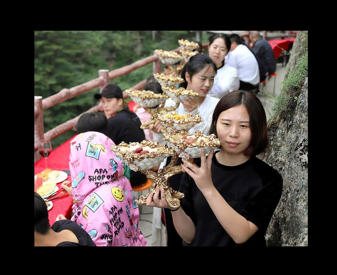 Centenares de turistas sin miedo a las alturas disfrutaron de cangrejos a la parrilla, champiñones fritos, frutas de temporada y vinos variados, suspendidos a más de 2.000 metros sobre el nivel del mar. El refrigerio de lujo, que formaba parte de un festival de verano celebrado en las paredes del Monte Laojun, en la provincia central de Henan, en China, se llevó a cabo en mesas dispuestas sobre una suerte de sendero de dos metros de ancho, unidas a la pared de roca. La montaña Laojun es uno de los destinos turísticos más populares de la provincia y es conocida porque fue el lugar de retiro de Laozi, el filósofo chino fundador del taoísmo. 