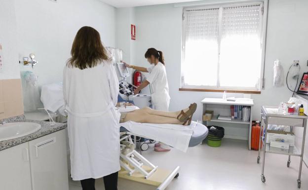 Una paciente es tratada por dos enfermeras.