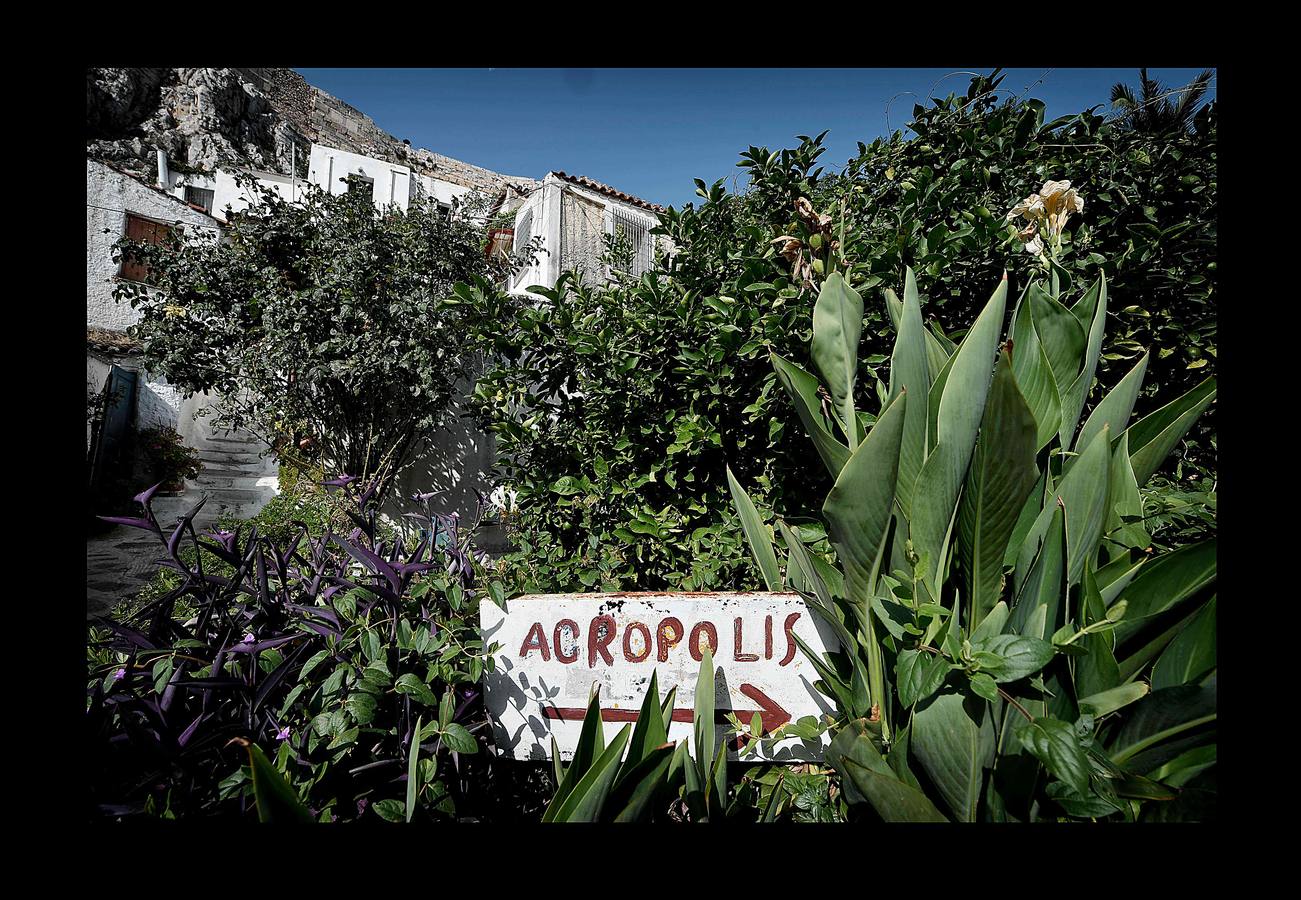 El distrito de Anafiotika, en Atenas, tiene el aire de un pintoresco pueblo de piedra sacado de las islas Cícladas, pero se encuentra a los pies de la Acrópolis. Quien ascienda por las estrechas y sinuosas calles del distrito de Plaka se sorprenderá ante la vista de un pueblo casi idéntico a los de las islas del mar Egeo. De hecho, las cien casas con techos de tejas, conocidas como Anafiotika, son tan antiguas como la capital griega moderna. Y es que para devolver a la ciudad su gloria clásica tras la guerra contra el imperio Otomano, el rey de Grecia invitó a los mejores canteros de la isla egea de Anafi a trabajar en su reconstrucción.