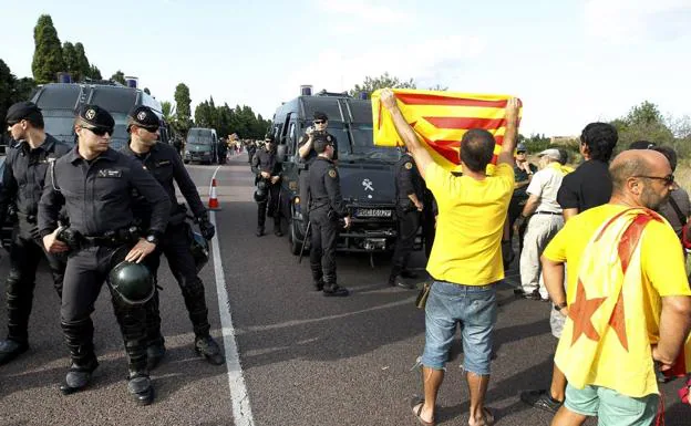 Un grupo de personas a favor de la indepencencia de Cataluña se manifiesta ante efectivos de la Guardia Civil.