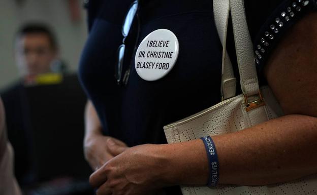 Una activista lleva una chapa de apoyo a Blasey Ford. 