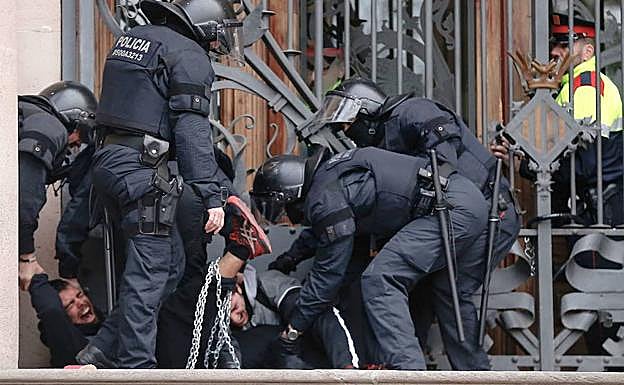 Imagen de archivo que muestra a mossos desalojando a personas encadenadas al TSJC el pasado febrero.