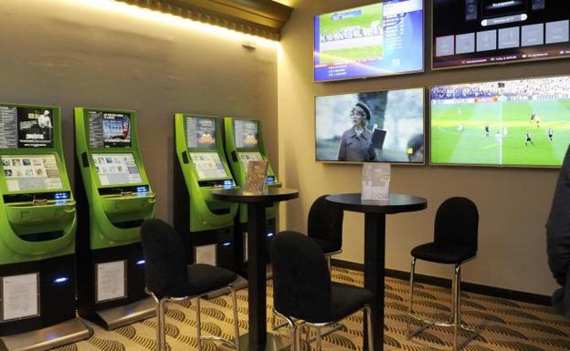 Rincón de apuestas en un casino de Castilla y León, con pantallas retransmitiendo partidos de fútbol.