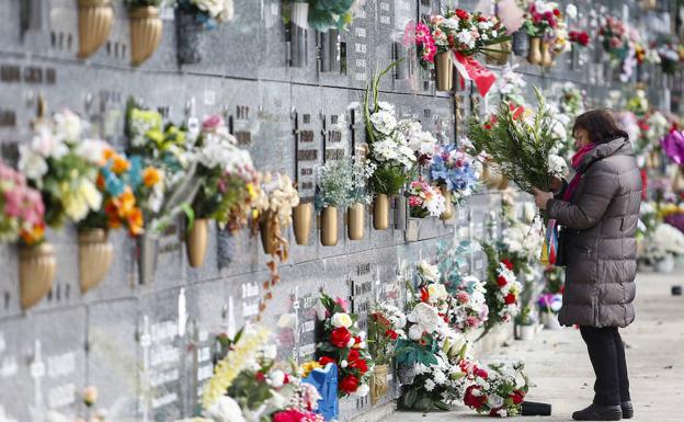 Una mujer sujeta un ramo en el Cementerio de León. 