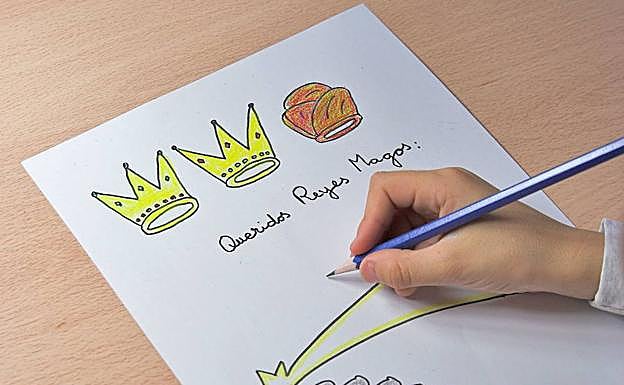 Un niño escribe la carta a los Reyes Magos.