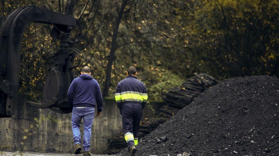 Dos mineros abandonan la explotación tras la última jornada de trabajo.