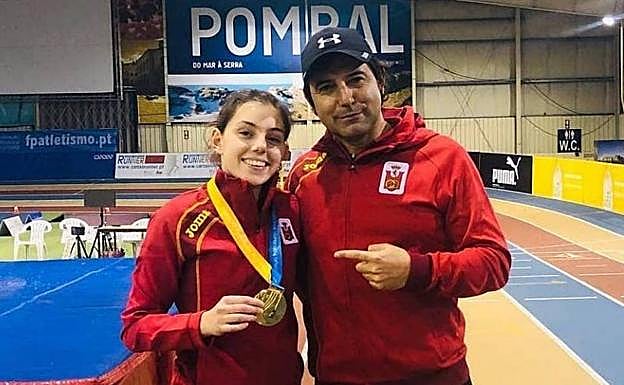 Nuria Menéndez posa con su oro junto a su entrenador, Alberto Menéndez.