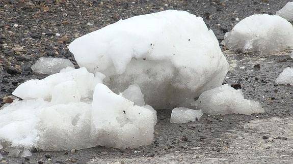 La nieve se acumula en la calzada.