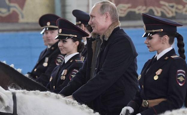 El presidente ruso, Vladimir Putin (2d), monta a caballo durante su visita al primer regimiento de policía operativa del Ministerio del Interior. 