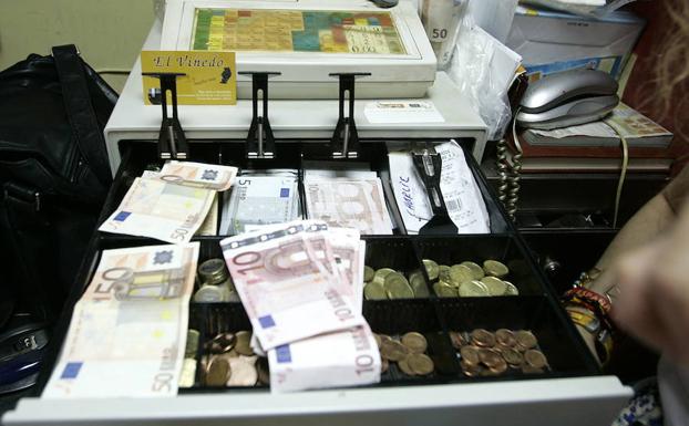 Billetes y monedas en una caja registradora.