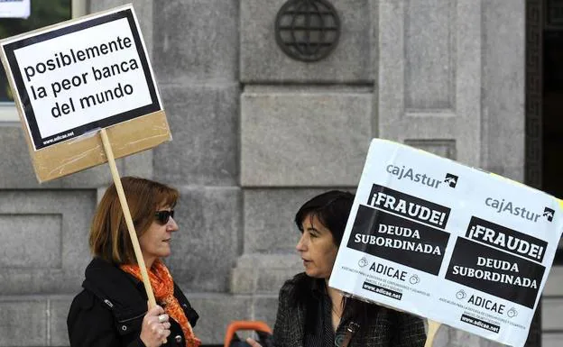 Varias personas protestan frente a la sede de Liberbank en Oviedo. 