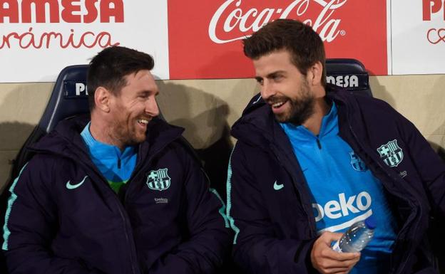 Leo Messi y Gerard Piqué se ríen en el banquillo de La Cerámica. 