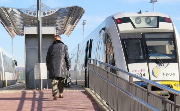 Imagen de una pasajera camino de un tren de vía estrecha.