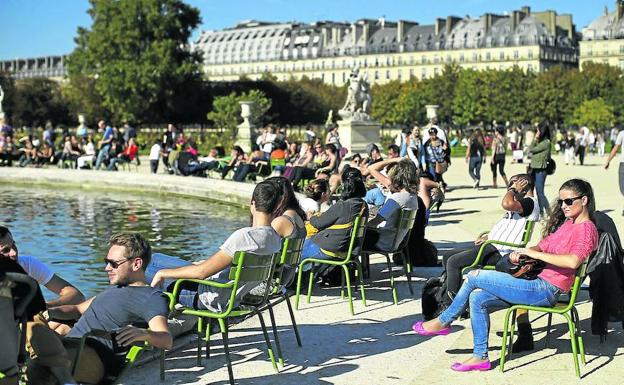 Un grupo de turistas disfruta del sol en el Jardín de las Tullerías, en el centro de la capital francesa.