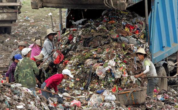 Imagen de archivo del vertedero de Wuhan (China), donde varias personas buscan entre la basura.
