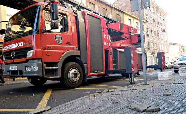 Los Bomberos de León retiran cascotes desprendidos de un edificio en la calle Burgo Nuevo