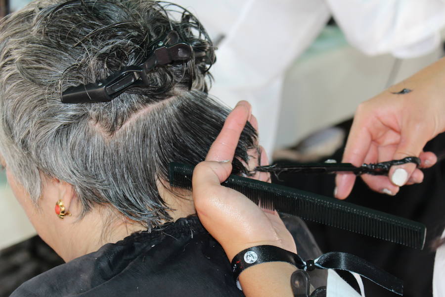 La céntrica plaza de San Marcelo se ha convertido en la jornada del domingo en un improvisado salón de belleza, en el que peluqueros, barberos, tatuadores, maquilladores y masajistas se han puesto a trabajar bajo la iniciativa 'León te corta' promovida por Víctor Valín en favor de la AECC