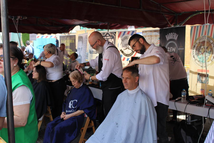 La céntrica plaza de San Marcelo se ha convertido en la jornada del domingo en un improvisado salón de belleza, en el que peluqueros, barberos, tatuadores, maquilladores y masajistas se han puesto a trabajar bajo la iniciativa 'León te corta' promovida por Víctor Valín en favor de la AECC