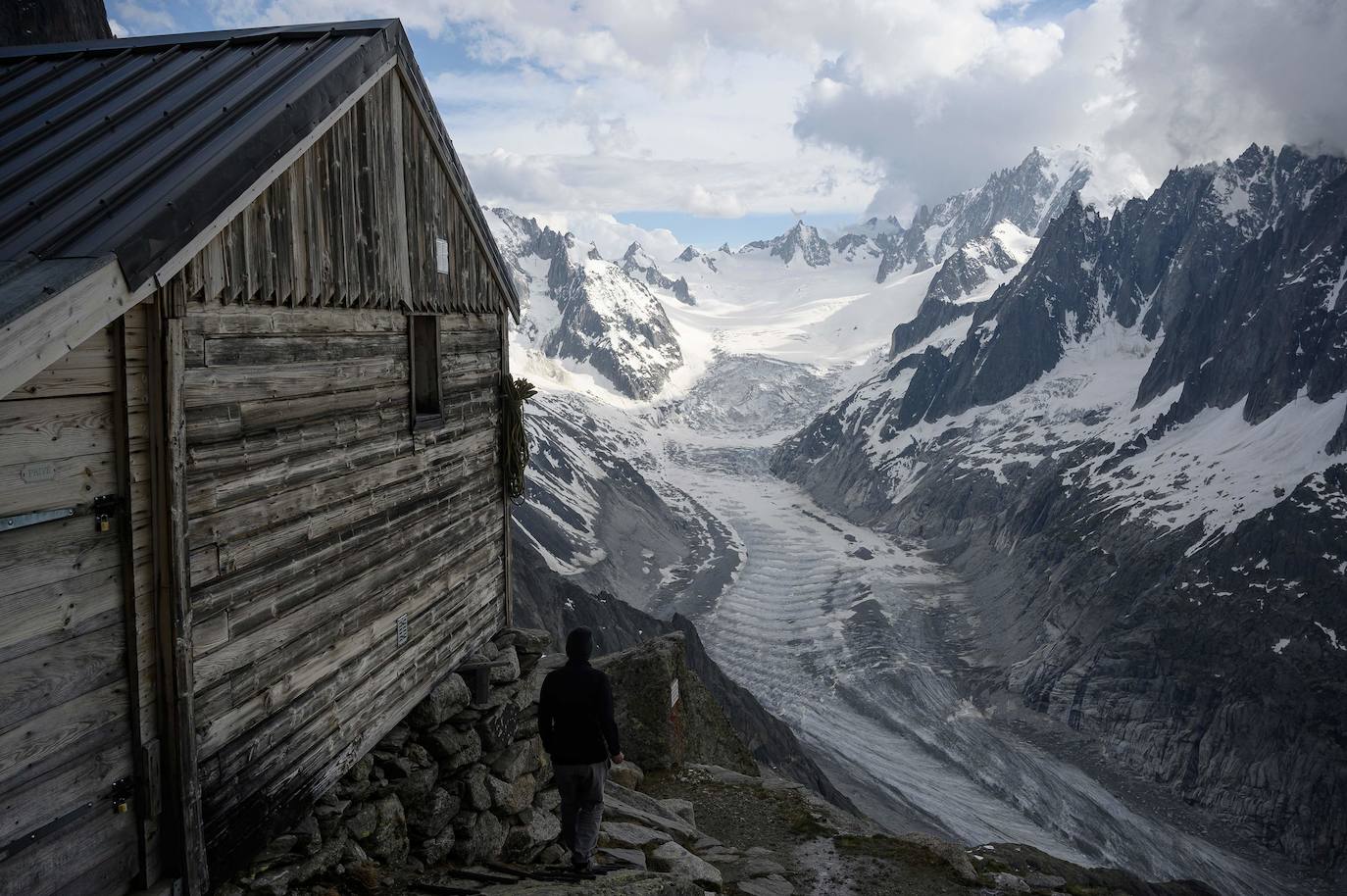 Sarah Cartier, guardesa del refugio de la Charpoua, camina junto a la cabaña. Al fondo, el glaciar del mismo nombre. 