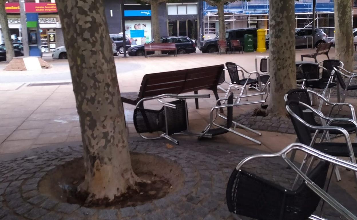 El vendaval acaba con las sillas de una terraza por los suelos.