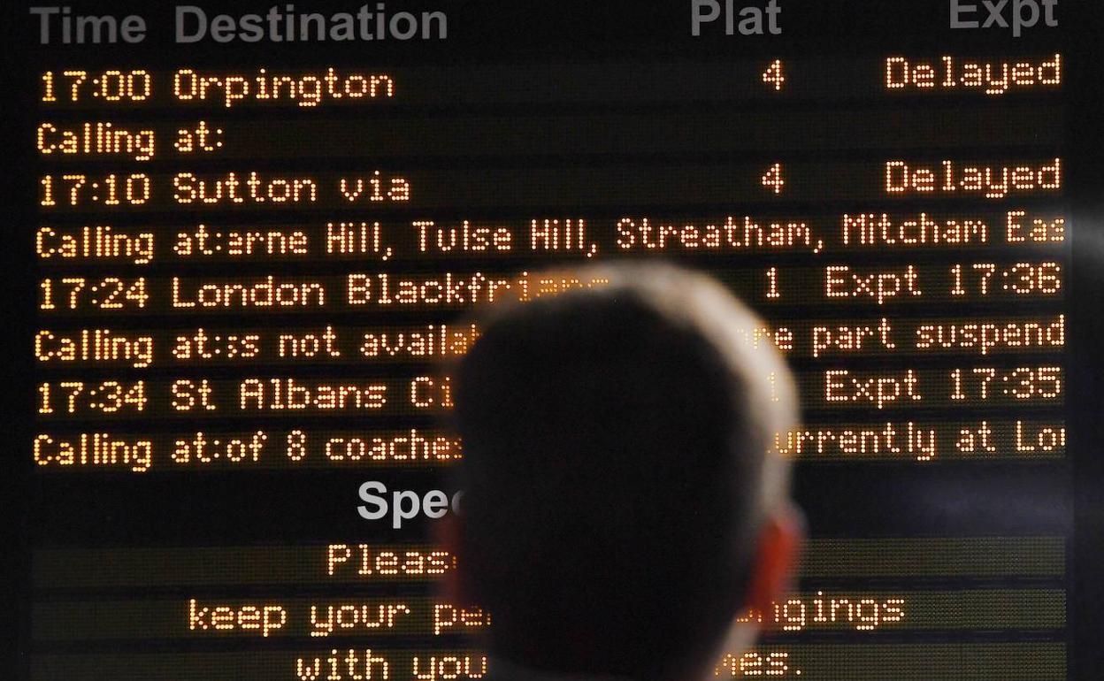 Un hombre observa las cancelaciones provocadas por el apagón en una estación británica. 