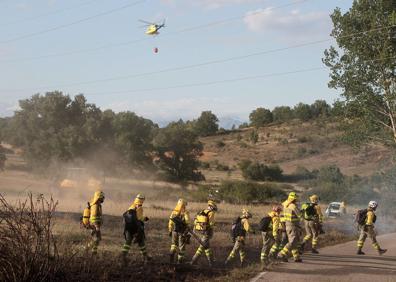 Imagen secundaria 1 - Brigadistas y helicópteros trabajando en la zona del incendio.