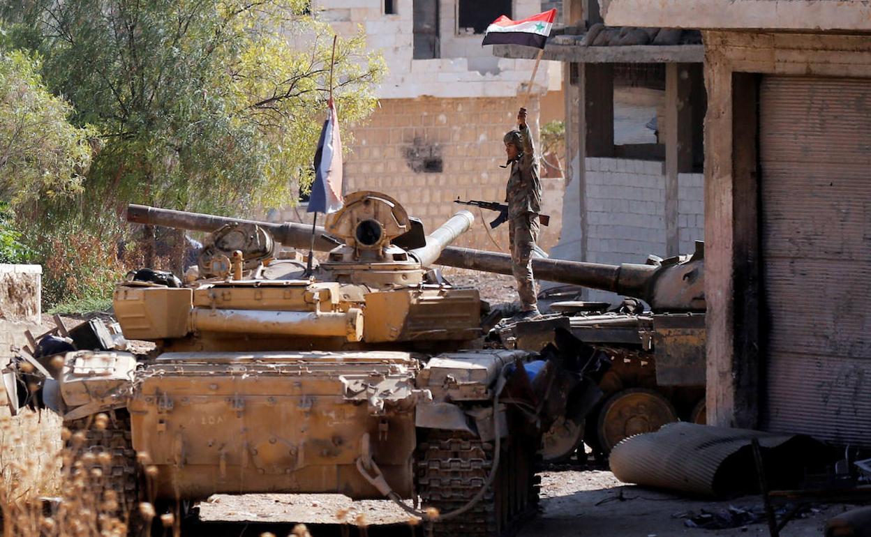 Un soldado sostiene la bandera siria en Idlib. 