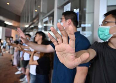 Imagen secundaria 1 - Los estudiantes de Hong Kong forman una cadena humana en varios distritos tras otro fin de semana de protestas