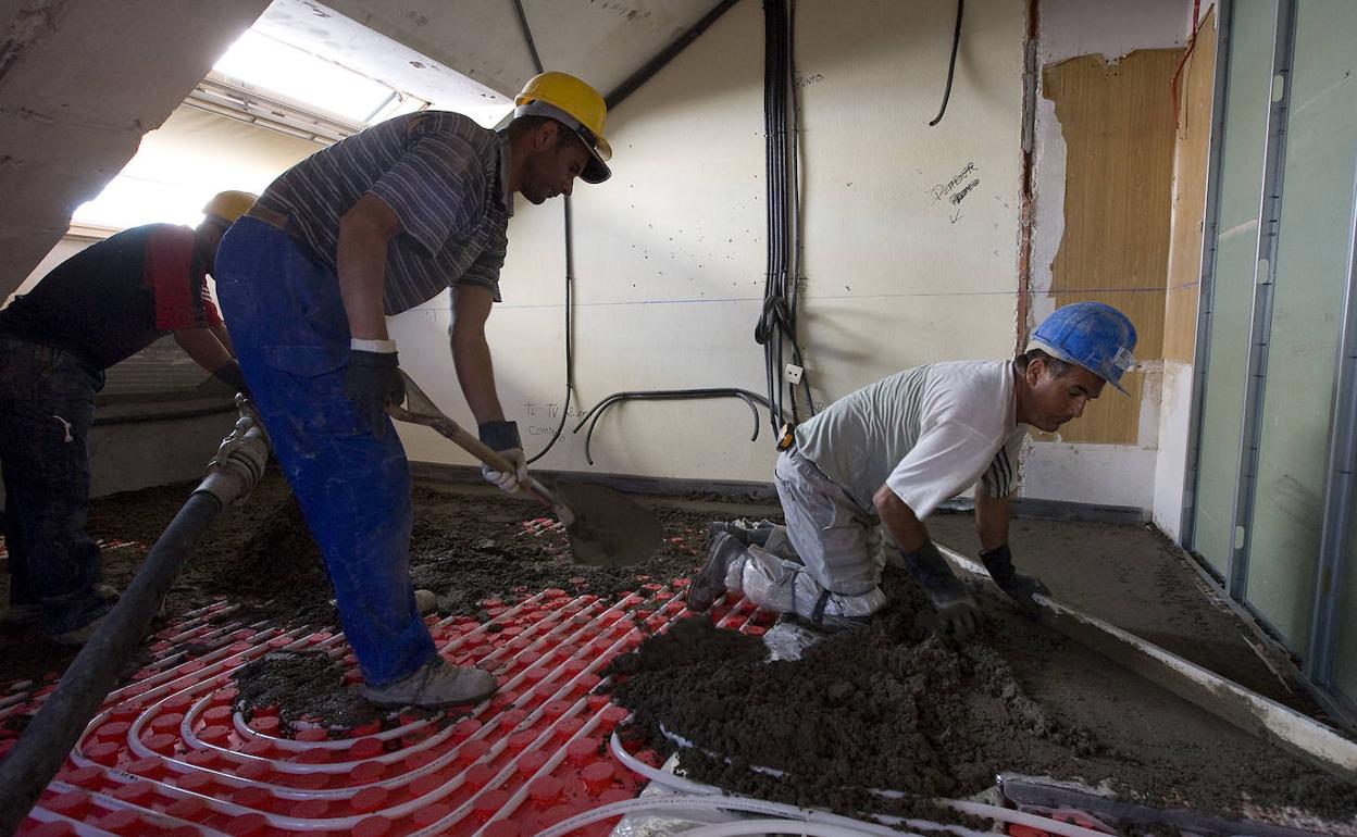 Trabajadores de la construcción en las obras de reforma de una vivienda. 