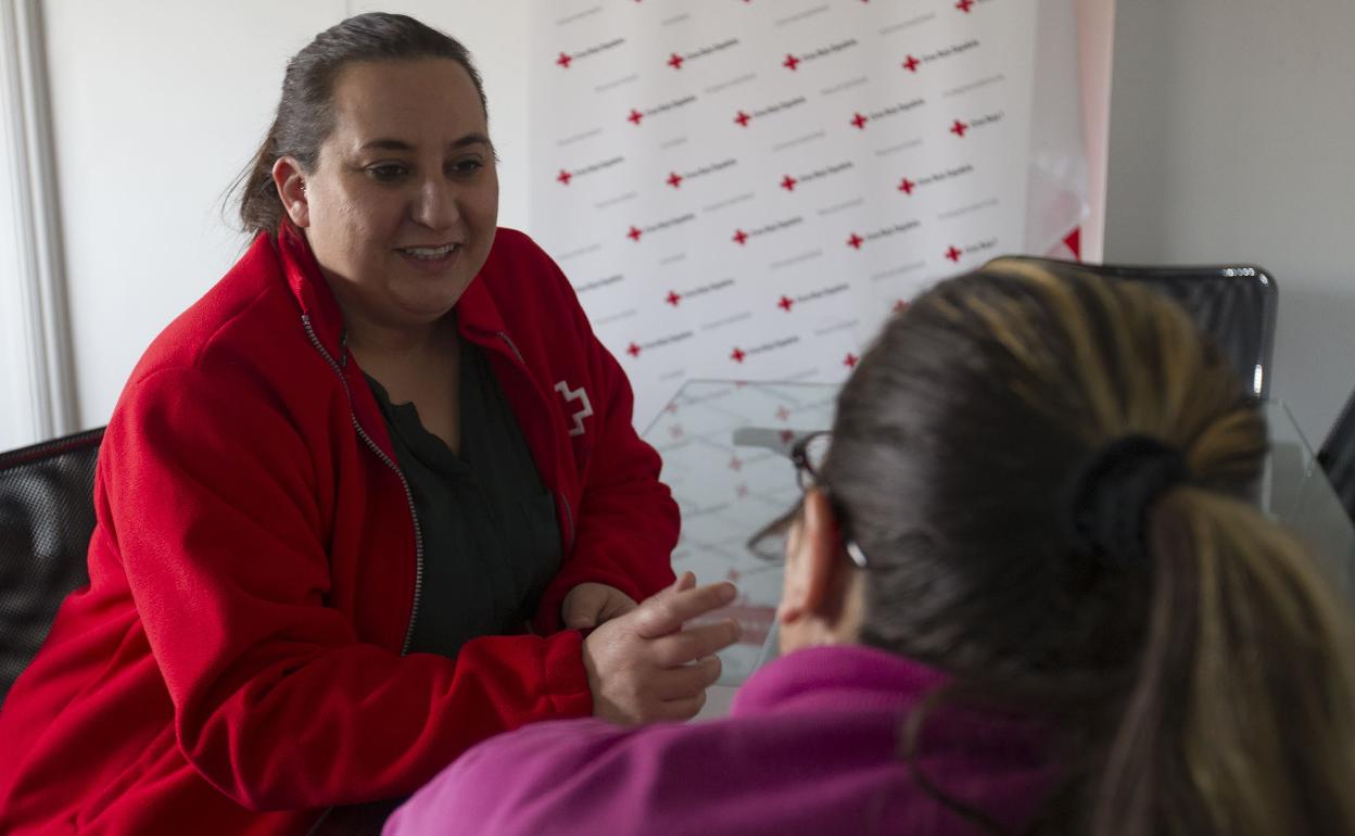 Una mujer, que pasa el invierno sin calefacción, conversa con una técnico de intervención familiar de Cruz Roja