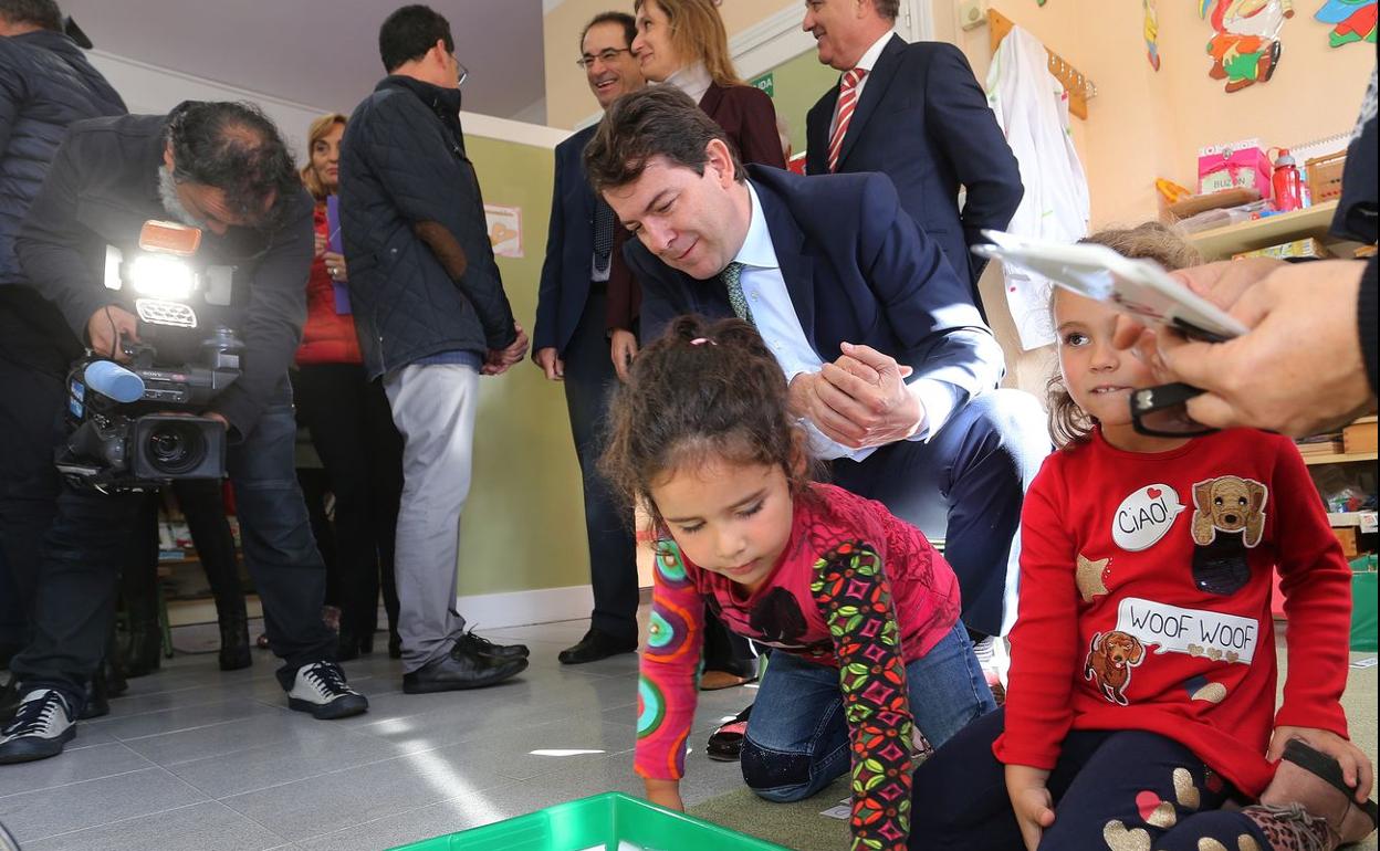 El presidente de la Junta de Castilla y León, Alfonso Fernández Mañueco (C); junto a dos niñas de colegio 'Padre Anastasio Gutierrez' de Santervás de la Vega, en su visita a varios centros educativos de la provincia de Palencia.