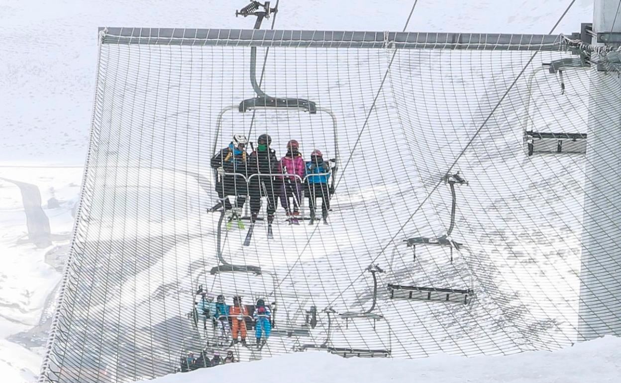 Esquiadores subiendo a las pistas en la estación invernal de San Isidro.