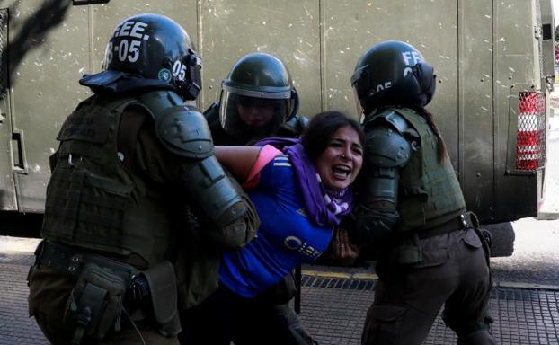 La Policía deteniene a uno de los manifestantes.