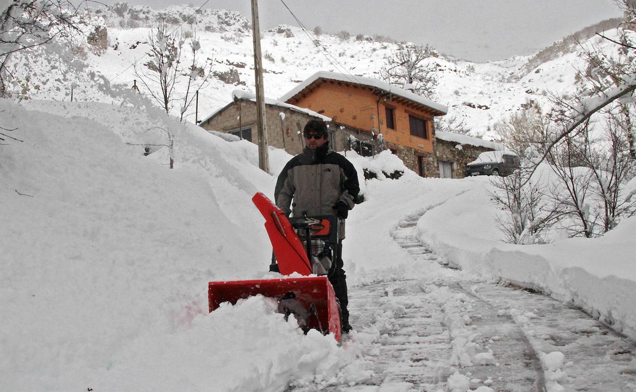 Un vecino de Pedrosa (León) despeja de nieve el acceso a su casa. 