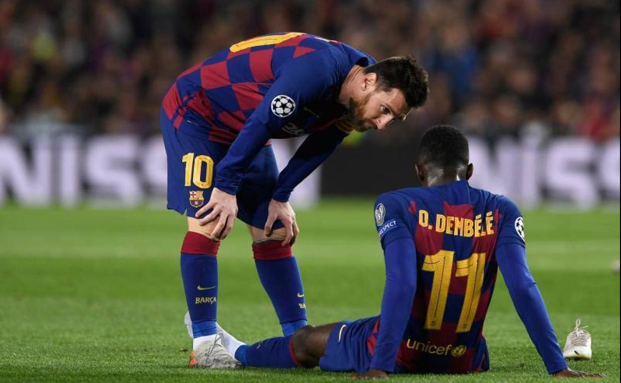 Messi se preocupa por Dembélé, desconsolado sobre el cesped del Camp Nou.