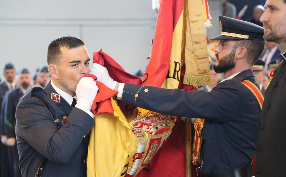 Uno de los caballeros alumnos besa la bandera rojigualda. 