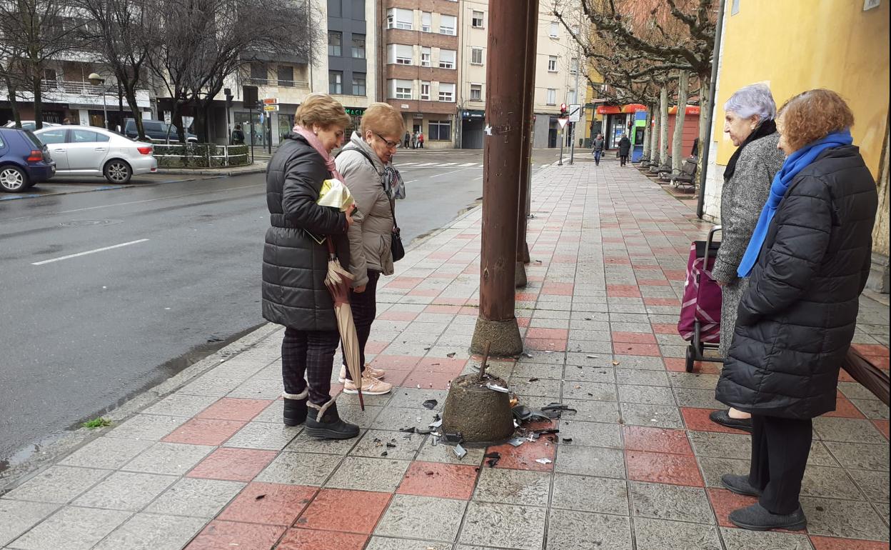 Un grupo de mujeres contempla la base del pilar. 