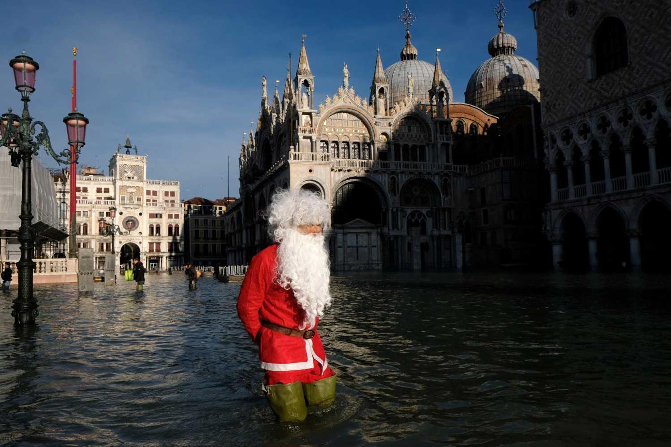 Santa Claus pasea por la inundada Plaza de San Marcos en Venecia