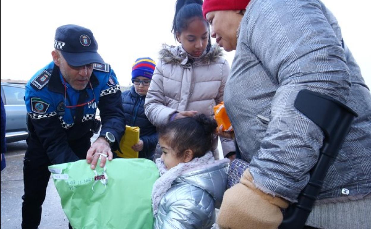 Un Policía Local de Ponferrada entrega juguetes recogidos en la campaña solidaria. 