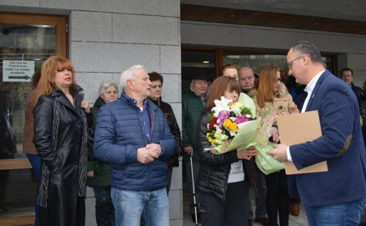 El alcalde, Óscar Ancares, entrega a la madre de Sheila, Julia Fernández, un ramo de flores.