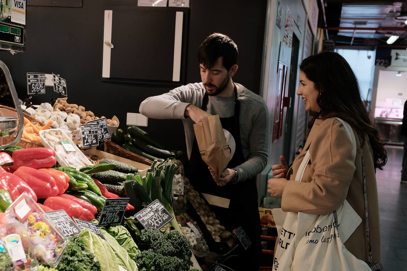 Paula compra los ingredientes para cocinar su receta favorita en el puesto de verduras 'A dos manzanas' del mercado de Barceló. 