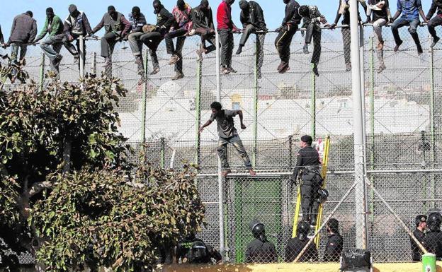 Varios inmigrantes intentando saltar la valla de Melilla