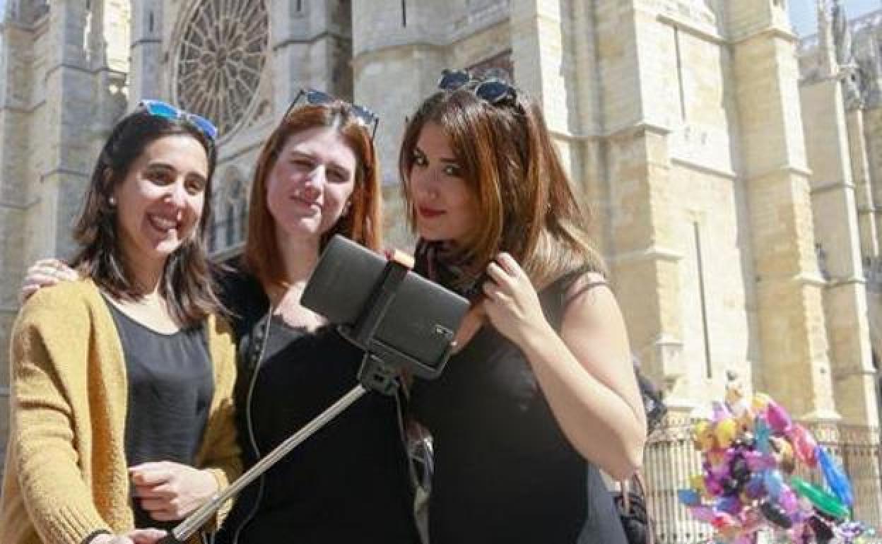 Tres turistas se hacen una foto en León. 