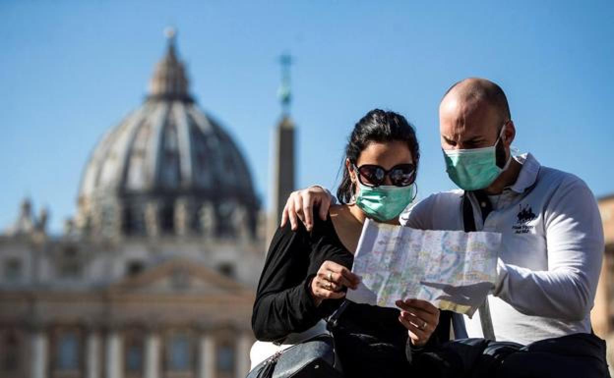 Una pareja observa un plano de espaldas al Vaticano. 