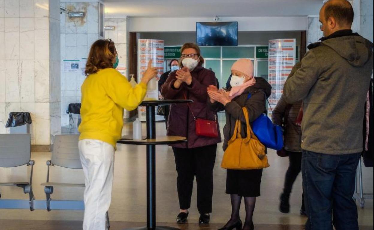 Varias personas charlan con una enfermera en un hospital de Cremona.